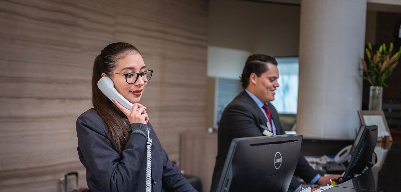 Two receptionists at their computers on the phone